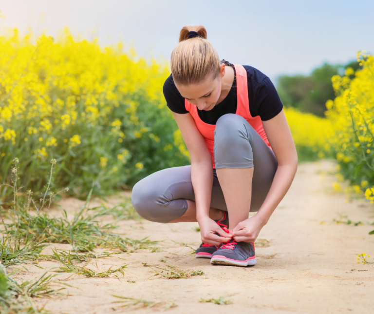 tying running shoes in a field