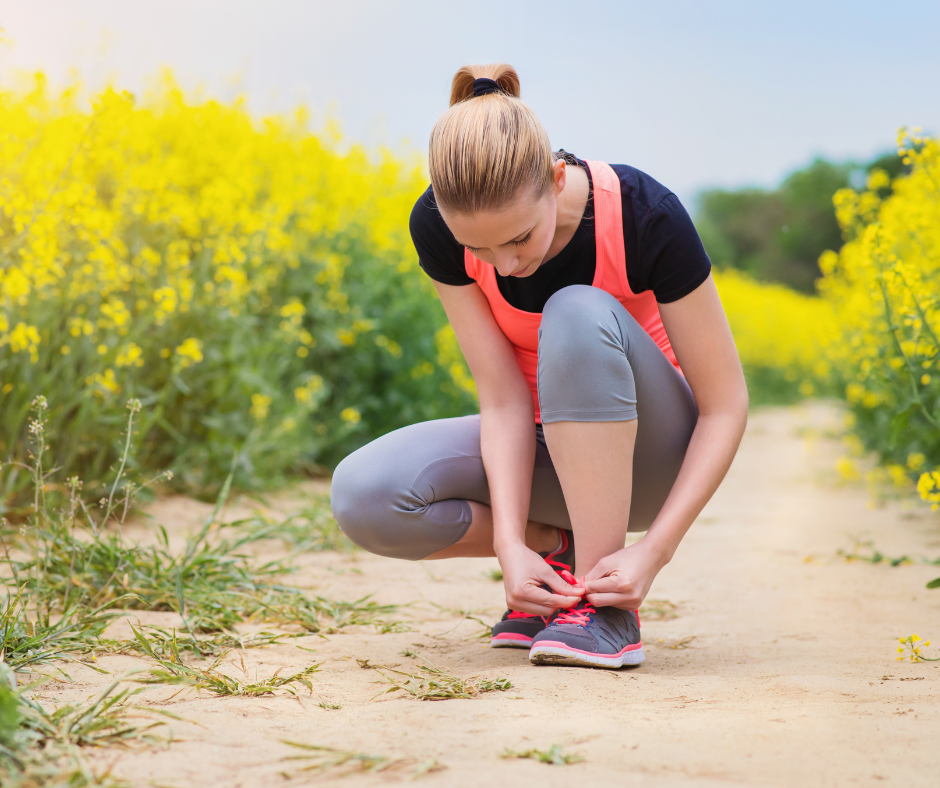 tying running shoes in a field