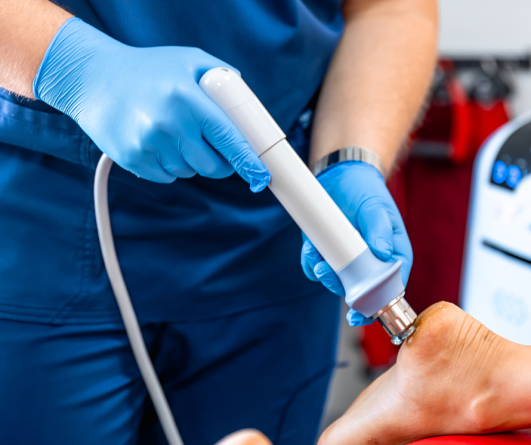medical professional performing shockwave therapy on foot